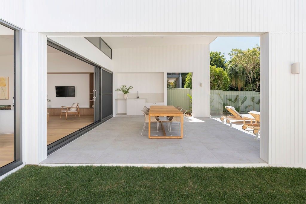 Bright white home opening onto a courtyard with AGS aluminium windows and doors on the Sunshine Coast