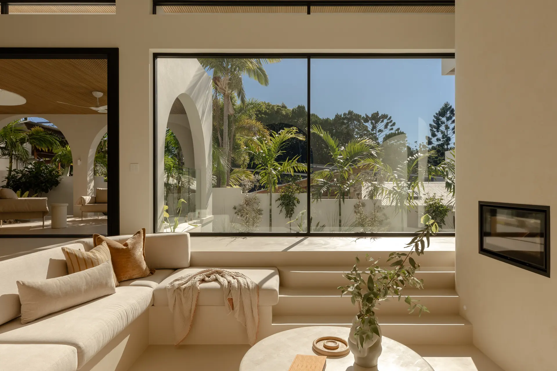 Sunshine Coast living room with large black-framed aluminium windows overlooking a courtyard